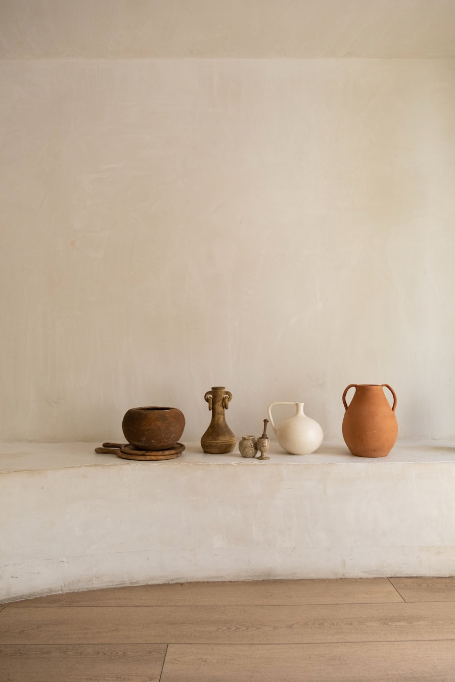 A row of small vessels arranged along a plaster ledge.